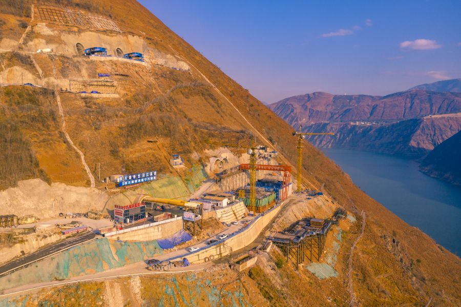 沿江高速寧巧隧道是川滇連接通道，在四川境連接涼山州寧南縣，在云南境連接昭通市巧家縣。該隧道為微瓦斯隧道，設(shè)計(jì)為雙洞雙向隧道，左線長度為9069米，右線為9103米，屬傍山特長隧道。隧道最大埋深639米，是國內(nèi)最長的凹型豎曲線高速公路隧道，隧道出口段采用整體式直中墻連拱形式，中墻厚度僅1.4米，是國內(nèi)高地震烈度區(qū)最薄的直中墻。.jpg
